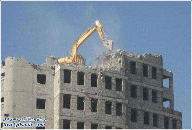 صور حفارة تهدم مبنى من السطوح